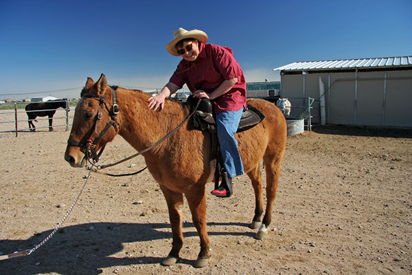 Jutta Engelhardt in western gear taking a horse back riding lesson at Chile Acres in Tonopah, Arizona